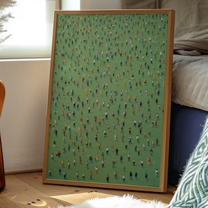 May include: A framed painting of a green field with many small figures of people standing on it. The frame is made of wood and has a light brown color.