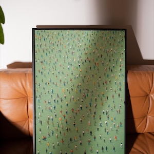 May include: A framed print of a painting depicting a large crowd of people standing on a green field. The people are all wearing different colored clothing and are arranged in a seemingly random pattern.