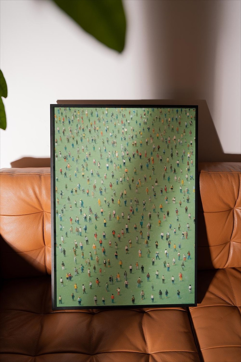 May include: A framed print of a painting depicting a large crowd of people standing on a green field. The people are all wearing different colored clothing and are arranged in a seemingly random pattern.