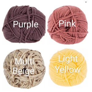 May include: Four balls of yarn in different colors: purple, pink, light yellow, and multi beige.