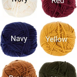 May include: Six balls of yarn in different colors: ivory, red, navy, yellow, brown, and olive. Each ball has the color name written on it.