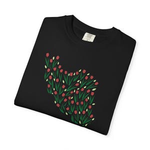 May include: Black t-shirt featuring a floral design of red tulips with green stems and leaves. The Comfort Colors label is visible on the upper right. The design is a stylized floral arrangement.