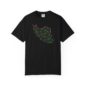 May include: Black t-shirt featuring a floral design in the shape of a heart. The design includes red flowers, green leaves, and white accents. The shirt is a classic crew neck style.