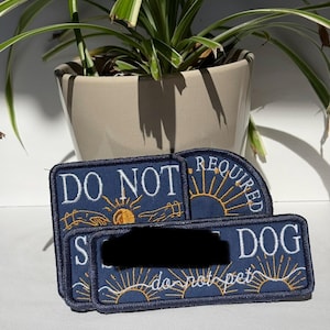 May include: Three rectangular navy blue embroidered patches with white text and gold sun motifs. The patches feature the phrases DO NOT, REQUIRED, and DOG, along with the text do not pet. The embroidery includes line art of hands reaching toward a sun.