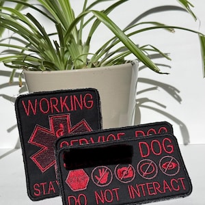 May include: Two rectangular black embroidered patches with red text and symbols. One patch features a red Star of Life symbol with the text WORKING and STAY. The other patch displays the text SERVICE DOG DO NOT INTERACT with five red icons.