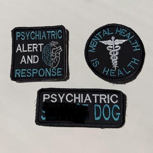 May include: Three black embroidered patches with light blue and white text. One square patch reads PSYCHIATRIC ALERT AND RESPONSE with a brain icon. One circular patch reads MENTAL HEALTH IS HEALTH with a caduceus. One rectangular patch reads PSYCHIATRIC SERVICE DOG.
