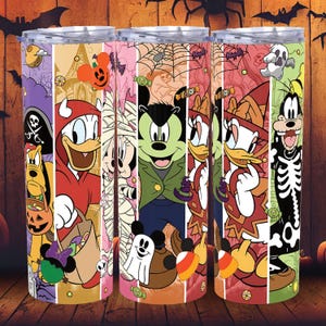 May include: Three stainless steel tumblers with Halloween-themed cartoon characters. The characters include Donald Duck, Mickey Mouse, and Goofy, dressed in costumes. The tumblers have a colorful design with bats, pumpkins, and candy corn.