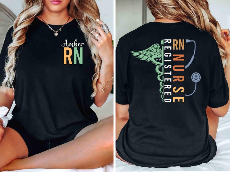 May include: Black t-shirt with "Amber RN" in orange and green on the front. The back features a green caduceus with wings, a stethoscope, and the words "RN NURSE REGISTERED" in orange, green, and white.