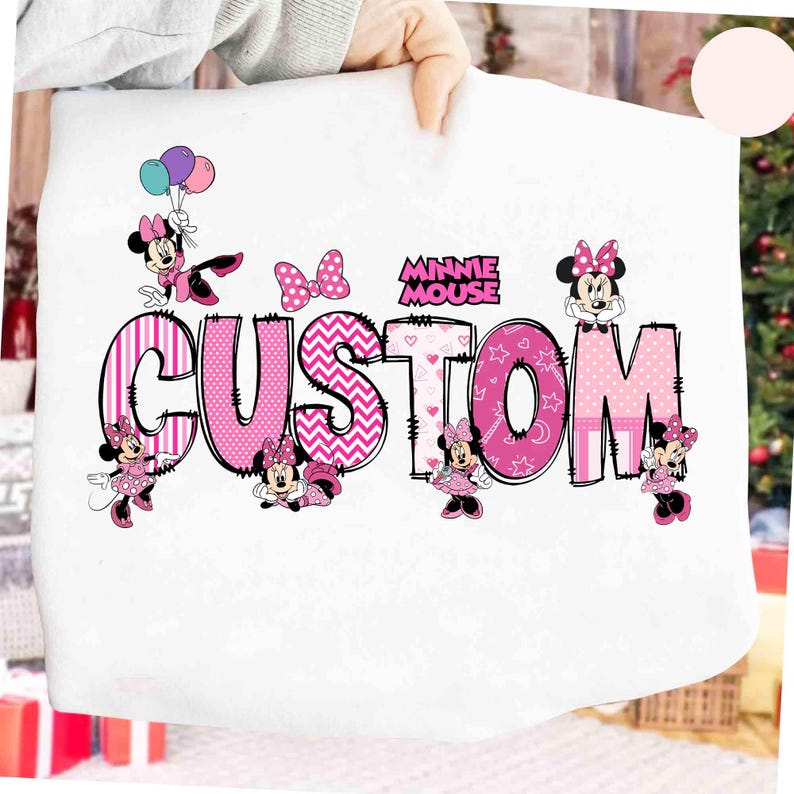 May include: White t-shirt with the pink word "CUSTOM" in a variety of patterns and Minnie Mouse graphics. The words "MINNIE MOUSE" are above the word "CUSTOM". Minnie Mouse is depicted with bows and balloons.