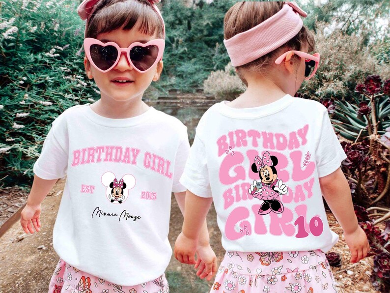 May include: Two children wearing white t-shirts with pink text that says "BIRTHDAY GIRL" and a Minnie Mouse graphic. The front of the shirt has "EST 2015" and "Minnie Mouse" text. The back of the shirt has "GIRL 10". They wear pink sunglasses and headbands.