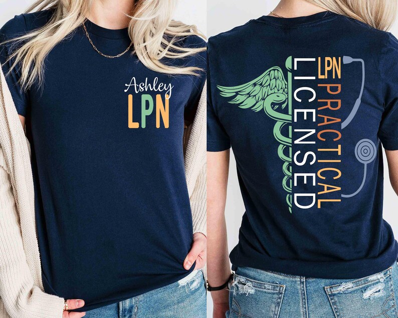 K&ouml;nnte beinhalten: Marineblaues T-Shirt mit dem Namen "Ashley" und "LPN" in Gr&uuml;n und Orange auf der Vorderseite. Auf der R&uuml;ckseite des Shirts befinden sich ein medizinisches Symbol, die Worte "PRACTICAL LICENSED LPN" und eine Stethoskop-Grafik.