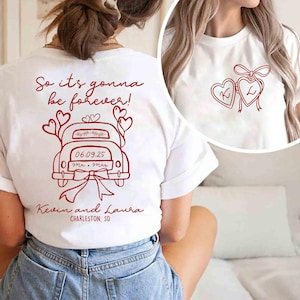 Puede incluir: Camiseta blanca con un diseño gráfico rojo. El diseño incluye un coche con corazones, el texto "So it's gonna be forever!", la fecha 06.09.25 y los nombres "Kevin and Laura". Un segundo diseño muestra dos corazones con las letras K y L.