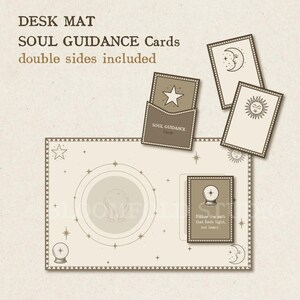 Op de afbeelding: Een beige bureaumat met een cirkelvormig ontwerp en sterren. De mat bevat vier kaarten met hemelse afbeeldingen en de tekst "SOUL GUIDANCE Cards" en "double sides included".