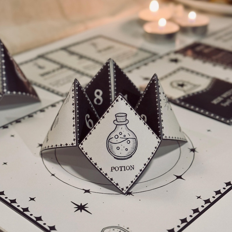 May include: A black and white printable potion-themed fortune teller game. The fortune teller is folded into a pyramid shape with the word "POTION" printed on the front. The fortune teller has numbers 6 and 8 printed on the sides.
