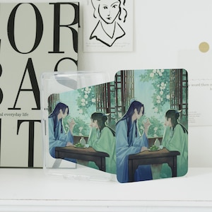 Op de afbeelding: Transparante telefoonhoes met een bedrukt ontwerp met twee figuren in blauwe en groene gewaden die aan een tafel zitten. De achtergrond toont een tuinscène met witte bloemen en een raam.