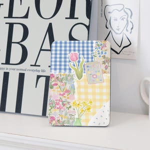 May include: A collage of floral patterns and checkered fabric in blue, yellow, and white. A single pink tulip is featured in the centre of the collage.