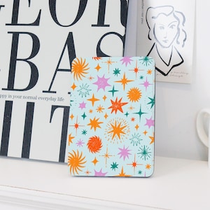 May include: A blue and white patterned phone case with orange, pink and green stars and sunbursts. The case has a matte finish.