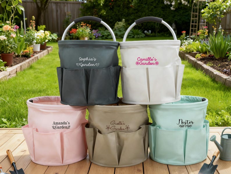 K&ouml;nnte beinhalten: Eine Auswahl an personalisierten Gartentaschen in verschiedenen Farben: Grau, Wei&szlig;, Rosa, Beige und Mintgr&uuml;n. Jede Tasche hat mehrere Au&szlig;entaschen und einen Metallgriff. Die Taschen sind mit Namen und dem Wort "Garden" bestickt.