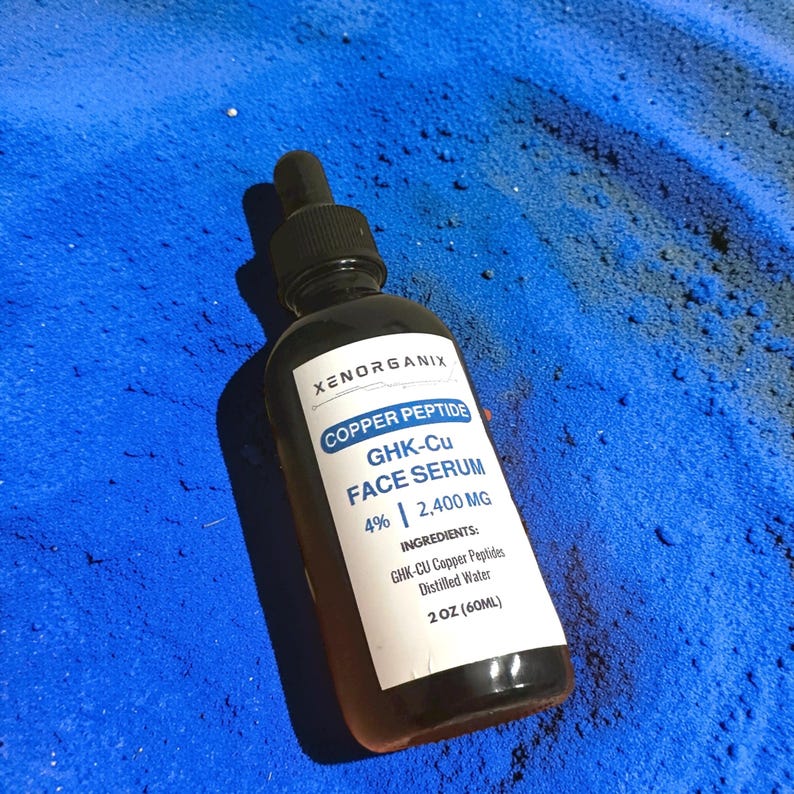 May include: A dark amber glass bottle with a black dropper cap containing Xenorganix Copper Peptide GHK-Cu Face Serum. The white label displays the text: Xenorganix, Copper Peptide, GHK-Cu Face Serum, 4% | 2,400 MG, Ingredients: GHK-CU Copper Peptides, Distilled Water, 2 OZ (60ML).