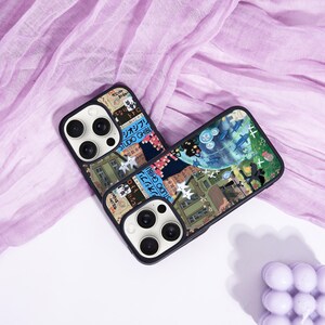 May include: Two black phone cases with a colorful collage design featuring Japanese text and illustrations. The cases have a black border and a camera cutout. The design includes images of buildings, characters, and other graphics.