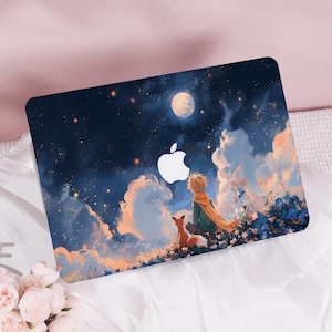 Peut inclure: Coque d'ordinateur portable avec une illustration onirique d'un garçon et d'un renard sous un ciel étoilé, avec une pleine lune et des nuages. Le design comprend un logo Apple blanc.