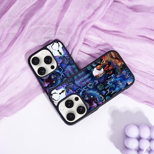 May include: Two black phone cases with a colorful, fantasy-themed design. The cases feature a dark blue and purple background with illustrations of a person, buildings, and other elements. The cases have a black border and a white camera module.
