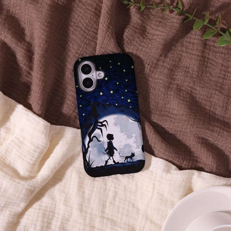 May include: Black phone case featuring a silhouette of a person and a cat walking in front of a full moon. The background has a dark blue sky with stars and a tree. The case has a glossy finish.