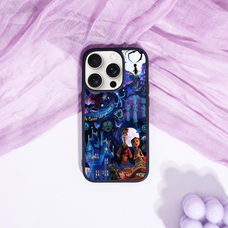 May include: Black phone case with a colorful illustration featuring a spooky house, characters, and the text "Be Careful what you wish for". The case has a dark blue border and a glossy finish.