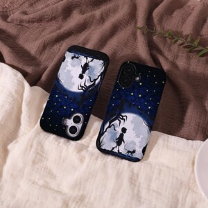 May include: Two black phone cases with a dark blue night sky design. The cases feature a full moon, silhouettes of trees, and a figure walking with a cat. The cases have a black border and camera cutouts.