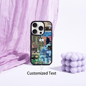 May include: A black phone case with a colorful collage design featuring illustrations and Japanese text. The case has a black border and a cutout for the camera. The text "Jindar" is visible on the case. The words "Customized Text" are below the phone case.