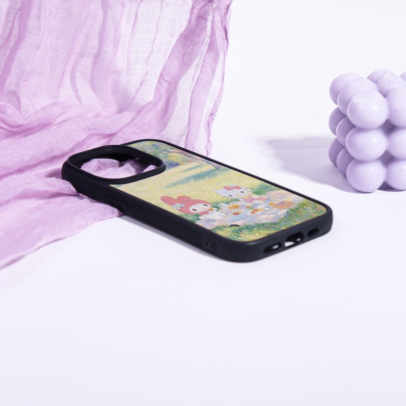 Puede incluir: Funda de tel&eacute;fono negra con una colorida ilustraci&oacute;n de personajes de dibujos animados en un campo. La funda tiene un borde negro y un dise&ntilde;o que incluye tonos rosas, blancos y amarillos. La funda est&aacute; dise&ntilde;ada para un tel&eacute;fono inteligente.