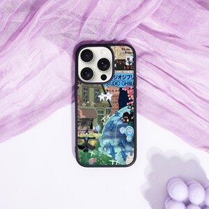 May include: Black phone case with a colorful collage design featuring Japanese animation characters and text. The case has a black border and a glossy finish, with a multi-camera lens cutout.