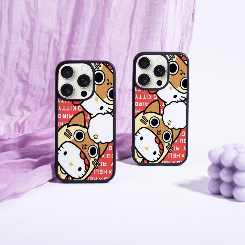 May include: Two black phone cases with a cartoon cat design. The cat is wearing a brown and yellow costume with a star. The background is red with white text that says "Hello Kitty".