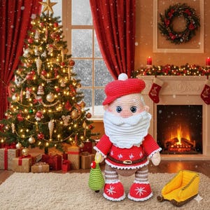Puede incluir: Mu&ntilde;eco de Pap&aacute; Noel tejido a ganchillo con gorro y traje rojos, barba blanca y pantal&oacute;n marr&oacute;n. El mu&ntilde;eco sostiene un peque&ntilde;o &aacute;rbol de Navidad verde. Un &aacute;rbol de Navidad decorado y una chimenea est&aacute;n en el fondo.