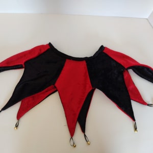 K&ouml;nnte beinhalten: Eine rot-schwarze Narrenkappe mit Gl&ouml;ckchen an den Enden der Spitzen. Die Kappe ist aus Samt.