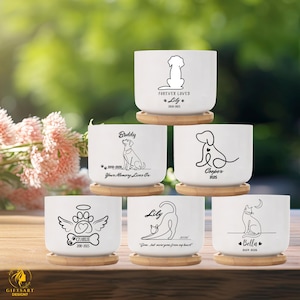 May include: White ceramic pet memorial planters with bamboo saucers. Each planter features a black graphic of a dog or cat, with the pet's name and dates. Some planters include the text "Forever Loved" or "Your Memory Lives On".