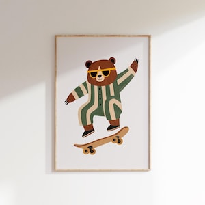 以下が含まれることがあります： サングラスと緑とクリーム色のストライプのジャンプスーツを着た茶色のクマがスケートボードをしている額入りのアートプリント。クマは空中にいて、片腕を上げています。スケートボードは、ライトブラウンで、ダークブラウンのホイールが付いています。