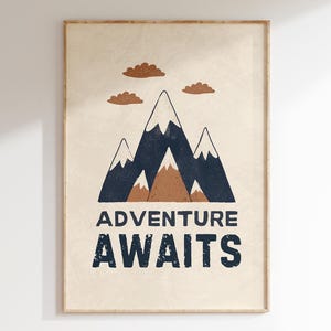 Puede incluir: Un póster beige con una ilustración de una cordillera en tonos azules y marrones. Las montañas tienen picos nevados y están rodeadas de pequeñas nubes marrones. El texto "Adventure Awaits" está impreso en negro debajo de las montañas.