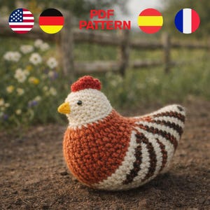 May include: A crocheted chicken in shades of cream, rust, and brown, with a red comb and yellow beak. The text "PDF PATTERN" is visible in the background. The chicken is sitting on the ground in front of a wooden fence and flowers.