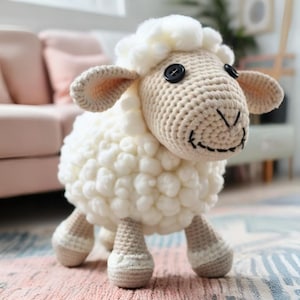 Op de afbeelding: Een wit gebreid knuffeldier van een schaap met zwarte knoopjes voor ogen. Het schaap heeft een pluche wit lichaam en bruine gebreide poten.