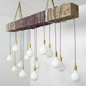 May include: A rustic wooden beam chandelier with multiple white globe light bulbs hanging from purple cords. The chandelier is suspended from the ceiling with brass chains.