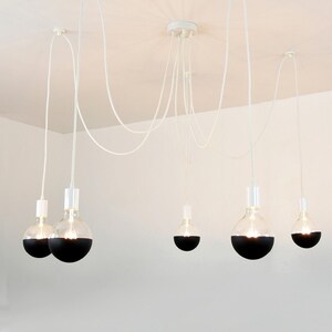 May include: A collection of six different ceiling light fixtures with various styles and colors. The lights are shown in different rooms, including a bathroom, bedroom, and living room. The lights are all suspended from the ceiling and have different types of bulbs, including Edison bulbs, globe bulbs, and cage bulbs.