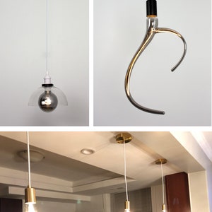 May include: Three different pendant lights with white cords. The first light has a clear glass shade with a silver bulb. The second light has a silver, curved, glass shade with a black cord. The third light has a gold metal shade with a white cord. The lights are hanging from a white ceiling.