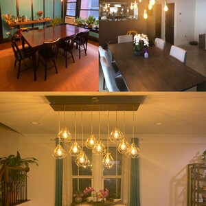 May include: A dining room with a wooden table and chairs, featuring a unique light fixture with multiple gold cage pendant lights. The light fixture is suspended from a wooden beam.