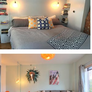 May include: A bedroom with a gray bed, a gray blanket with a geometric pattern, and two pillows with geometric patterns. There are bookshelves on the wall with books and a light fixture hanging from the ceiling.