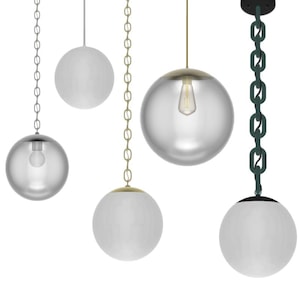 May include: A collection of spherical pendant lights. Some have clear glass globes, others are opaque white. They hang from chains or wires in various colors, including silver, gold, and dark green. Each light has a different design.