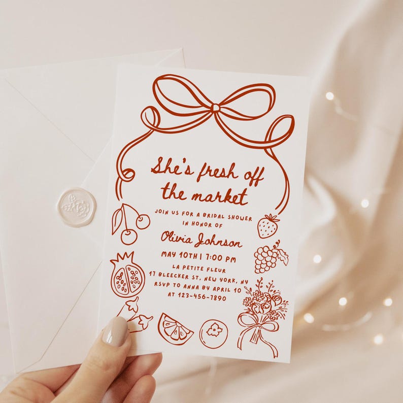 May include: A red and white bridal shower invitation with a hand-drawn illustration of a bow and various fruits and vegetables. The text reads "She's fresh off the market" and includes the bride's name, date, time, and location.