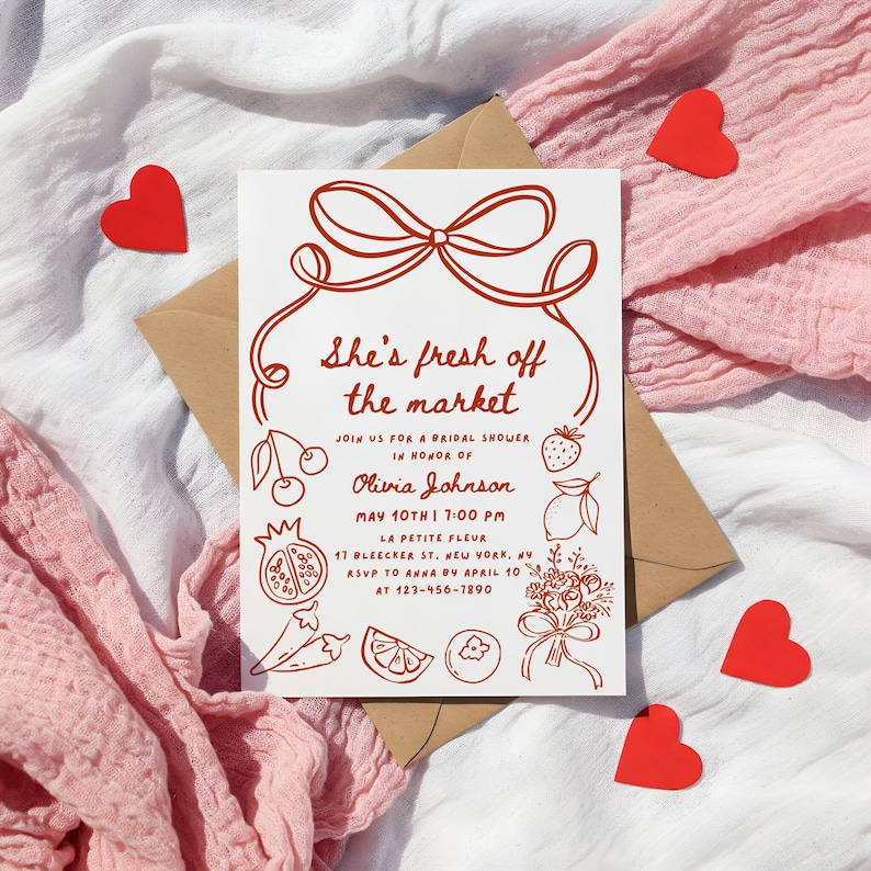 May include: A white bridal shower invitation with a red bow and the text "She's fresh off the market". The invitation includes details about the event, including the date, time, location, and RSVP information.