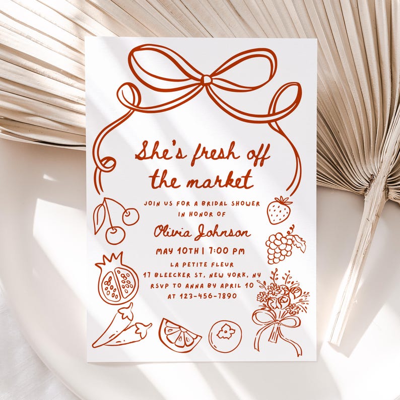 May include: A red and white bridal shower invitation with a hand-drawn illustration of a bow, cherries, a strawberry, grapes, a pomegranate, peppers, an orange, and a bouquet of flowers. The text reads "She's fresh off the market" and includes the bride's name, date, time, and location.
