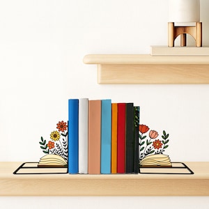May include: A display of books on a wooden shelf, held in place by decorative bookends with floral designs. The books are various colors, and a small potted plant sits on a shelf above. The brand name "LUXLAYEREDred" is visible.